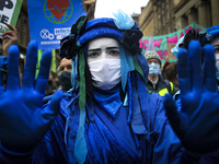 Extinction Rebellion protestors march though the city centre on day four of the COP 26 United Nations Climate Change Conference on November...