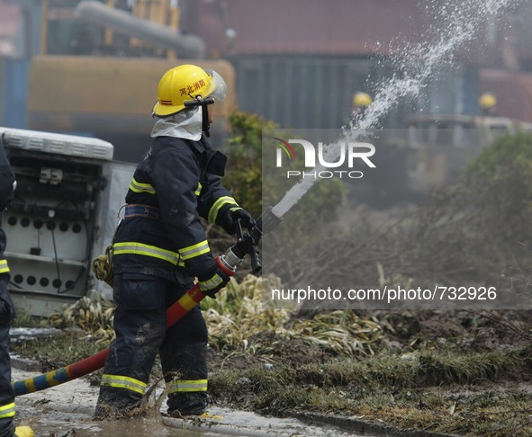 TIANJIN, Aug. 14, 2015 () -- A firefighter puts out flames in a container at the site of the explosion in Tianjin, north China, Aug. 14, 201...
