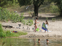 People swim and sunbathe on the shore  of Verbne lake in Kiev where several people were deadly infected with leptospirosis. Several people w...