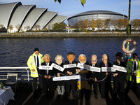 Activists wearing world leader heads protest on south bank of the river Clyde across from the Scottish Event Campus on day five of the COP 2...