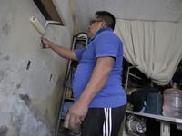 Nashel Torres, general assistant, paints the interior of a tailor's shop during the COVID-19 health emergency and the green epidemiological...