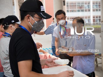 Volunteers handing out food supply in the temporary camp just before they are being evacuated to a safer location. - Death toll has risen to...
