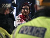 Police lead away one of the two Extension Rebellion activist who locked themselves together outside Santander at St Vincent Street on day te...