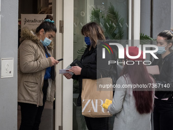 An employee checks Coronavirus (Covid-19) vaccine certifications at the enter of a shop in the center of Athens, Greece on November 10, 2021...