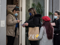 An employee checks Coronavirus (Covid-19) vaccine certifications at the enter of a shop in the center of Athens, Greece on November 10, 2021...