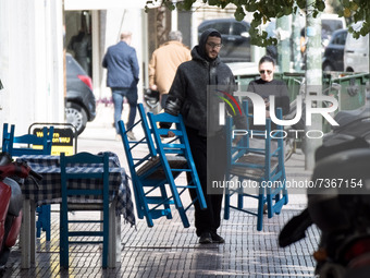 An employee carries chairs at the enter of a shop in the center of Athens, Greece on November 10, 2021. Mandatory negative Coronavirus (Covi...