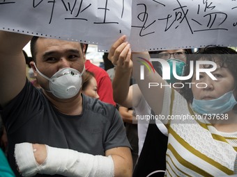 A resident who injured his arm during the explosion joining the protest to demand compensation from the government. - Hundreds of residents...