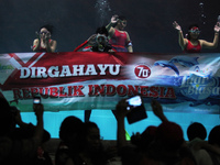 Some divers waving banners in order to celebrate the independence of the Republic of Indonesia in a giant aquarium, located in Jakarta, Mond...