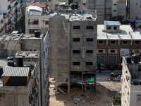 Palestinian workers dismantle a building in Gaza City's Al-Rimal neighbourhood, which was targeted by Israeli airstrikes last May during the...