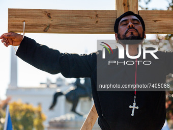 Immigration activist Francisco Aguirre hangs on a wooden cross during a direct action by the National TPS Alliance at the White House.  Acti...