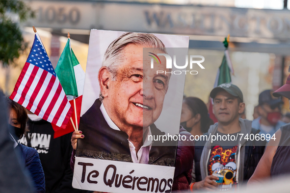 A protester carries a photo of Mexican President Andrés Manuel Lopez Obrador with the words, 