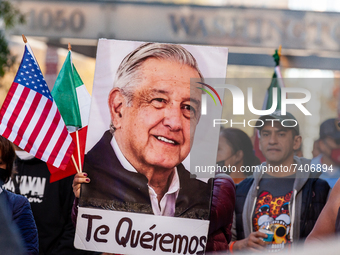 A protester carries a photo of Mexican President Andrés Manuel Lopez Obrador with the words, 