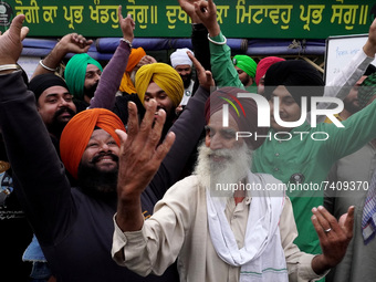 Farmers celebrate at a protest site after Prime Minister Narendra Modi announced that he will repeal the controversial farm laws, at Singhu...