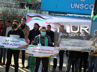 Palestinians gather in front of national flags during a protest in solidarity with Palestinian prisoners on hunger strike in Israeli jails,...