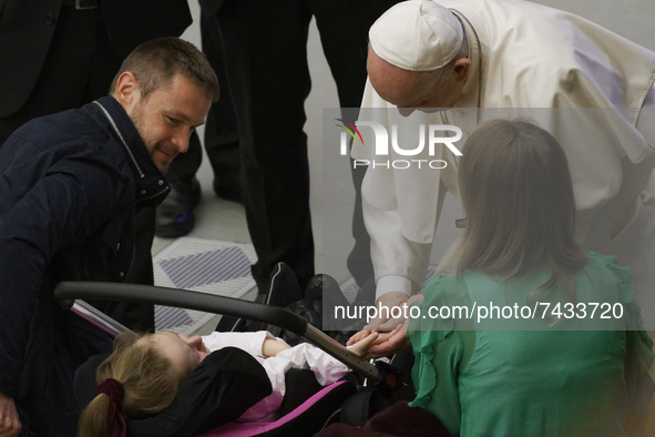 Pope Francis caresses a baby as he salutes faithful at the end of his weekly general audience in the Paul VI Hall at the Vatican, Wednesday,...
