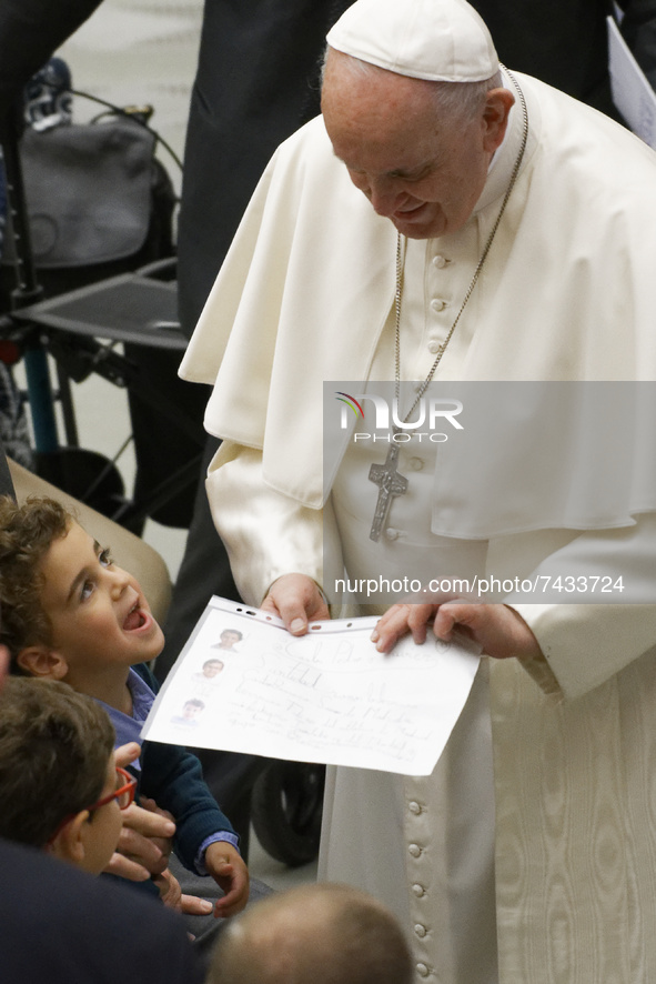 Pope Francis enjoy with a baby's as he salutes faithful at the end of his weekly general audience in the Paul VI Hall at the Vatican, Wednes...
