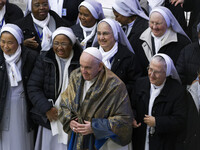 Pope Francis wears a scarf he was gifted by nuns at the end of his weekly general audience in the Paul VI Hall at the Vatican, Wednesday, De...