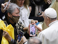 A woman shows a phone with a young child to Pope Francis at the end of his weekly general audience in the Paul VI Hall at the Vatican, Wedne...