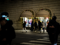 People wearing protective masks walk past Christmas decorations and buy gifts on December 20, 2021, in Rome, Italy, amid the COVID-19 pandem...