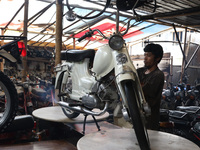 Workers replace antique motorcycle parts which are being restored at the old Motor Gallery in Pondok Cabe, Tangerang, December 29, 2021. The...