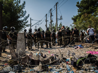 Migrants wait for Macedonian police to allow them to cross in Macedonia at the border line between Greece and Macedonia near the town of Gev...