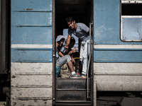 Migrants board a train towards Serbia at the new transit center on the border line between Greece and Macedonia near the town of Gevgelija o...