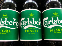 Carlsberg logos are seen on beer bottles at the shop in Krakow, Poland on December 31, 2021. (