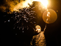 A man hold a flare while celebrating New Year at Krakus Mound in Krakow, Poland on 1st January 2022.
 (