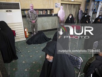 Unidentified veiled women sit next to an effigy of the Iranian top military commander General Qasem Soleimani who was killed in a U.S. drone...