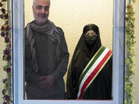 An Iranian veiled woman poses for a photograph with an effigy of the Iranian top IRGC commander, General Qasem Soleimani who was killed in a...