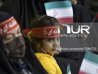 An Iranian young girl wearing a red headband with the name of Iran’s Supreme Leader Ayatollah Ali Khamenei, looks on while attending a death...