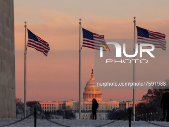 People watch a beautiful sunset over the Capitol from the Washington Monument after an unexpected snowstorm dumped roughly 8 inches on Washi...