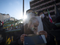 An Iranian woman holds a portrait of former commander of the Islamic Revolutionary Guard Corps (IRGC) Quds Force General Qasem Soleimani who...