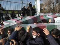 Iranian mourners carrying coffins containing remaining bodies of Iranian warriors who have been killed during the Iran-Iraq war, while takin...