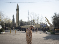 An Iranian Islamic Revolutionary Guard Corps (IRGC) military personnel walks past Iranian Qiam short-range surface-to-surface ballistic miss...
