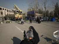 An Iranian veiled woman holds a portrait of Iran’s Supreme Leader Ayatollah Ali Khamenei as the Iranian solid-propelled road-mobile single-s...