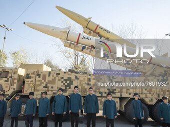 Iranian schoolboys stand under the Iranian Solid-propelled road-mobile single-stage missile, Zolfaghar Basir (Top), and Dezful medium-range...