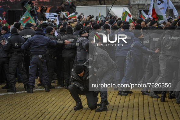 Police officer helps his injured colleague during protest against green certificates and vaccinations on January 12, 2022 in Sofia, Bulgaria...