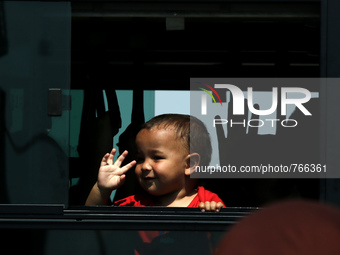 A baby is seen together with other immigrants in a bus going to the Piraeus railway station, on September 5, 2015.  The chartered by the Gre...