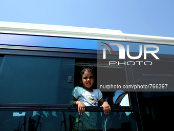 A girl looks on from a bus window going to the Piraeus railway station, on September 5, 2015.  The chartered by the Greek government passeng...