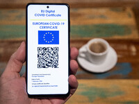 Photo illustration of a display of a mobile phone with a European EU digital Covid-19 vaccination certificate with a QR, an international va...