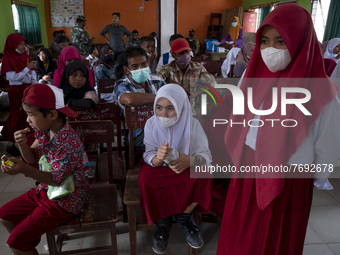 Students and their parents wait their turn to take a COVID-19 vaccination at SD Negeri Porame, Porame Village, Sigi Regency, Central Sulawes...