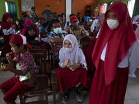 Students and their parents wait their turn to take a COVID-19 vaccination at SD Negeri Porame, Porame Village, Sigi Regency, Central Sulawes...