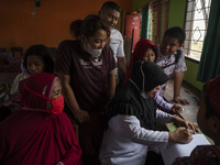 Parents register their children for the COVID-19 vaccine at SD Negeri Porame, Porame Village, Sigi Regency, Central Sulawesi Province, Indon...