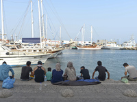 Migrants sitting in Kos harbor, on the Greek island of Kos, on September 7, 2015. The head of the European Union's executive says 22 of the...
