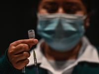 A nurse prepares the Pfizer-BioNTech COVID-19 vaccine for use at the Brothers Dominguez City Theater vaccination centre in San Cristobal de...