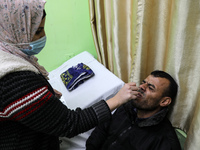 A Palestinian health worker takes a nasal swab from a man to test for the Covid-19 coronavirus, at Shifa hospital in Gaza City, Feb. 2, 2022...