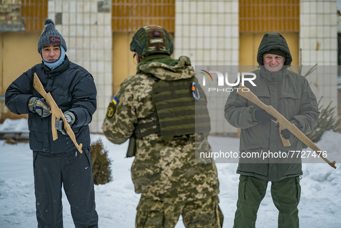 Soldier trainer of the 112th Territorial Defense Brigade of Kiev explains how to hold a rifle to a couple of civilian volunteers during a mi...