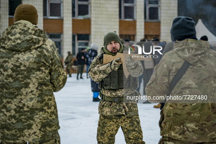A trainer of the 112th Territorial Defense Brigade of Kiev explains how to hold a rifle to the civilian volunteers in a military exercise in...