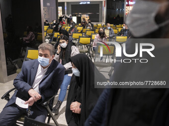 Iranian people wearing protective face masks wait to receive a dose of the new coronavirus disease (COVID-19) vaccine during the mass genera...